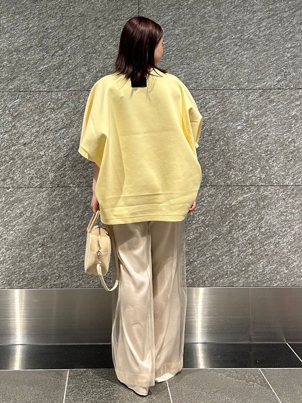 ベージュ系のスラックス、ベージュ系のスラックス、イエロー系のTシャツ/カットソーを着用したレディースの冬コーディネートの3枚目の写真