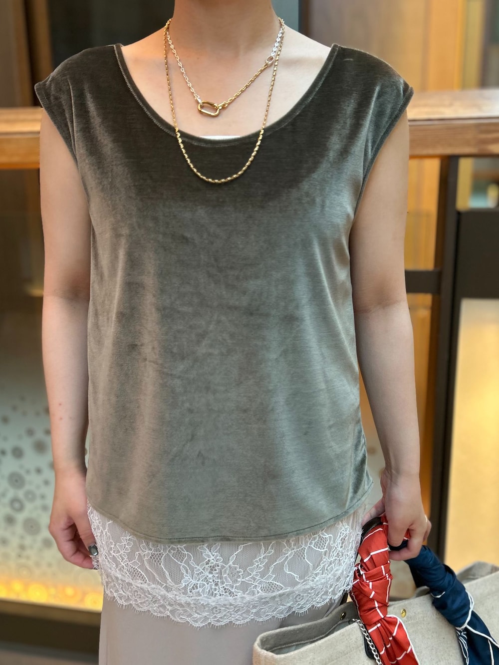 ホワイト系のキャミソール、ベージュ系のスカート、グリーン系のTシャツ/カットソーを着用したレディースの夏コーディネートの6枚目の写真