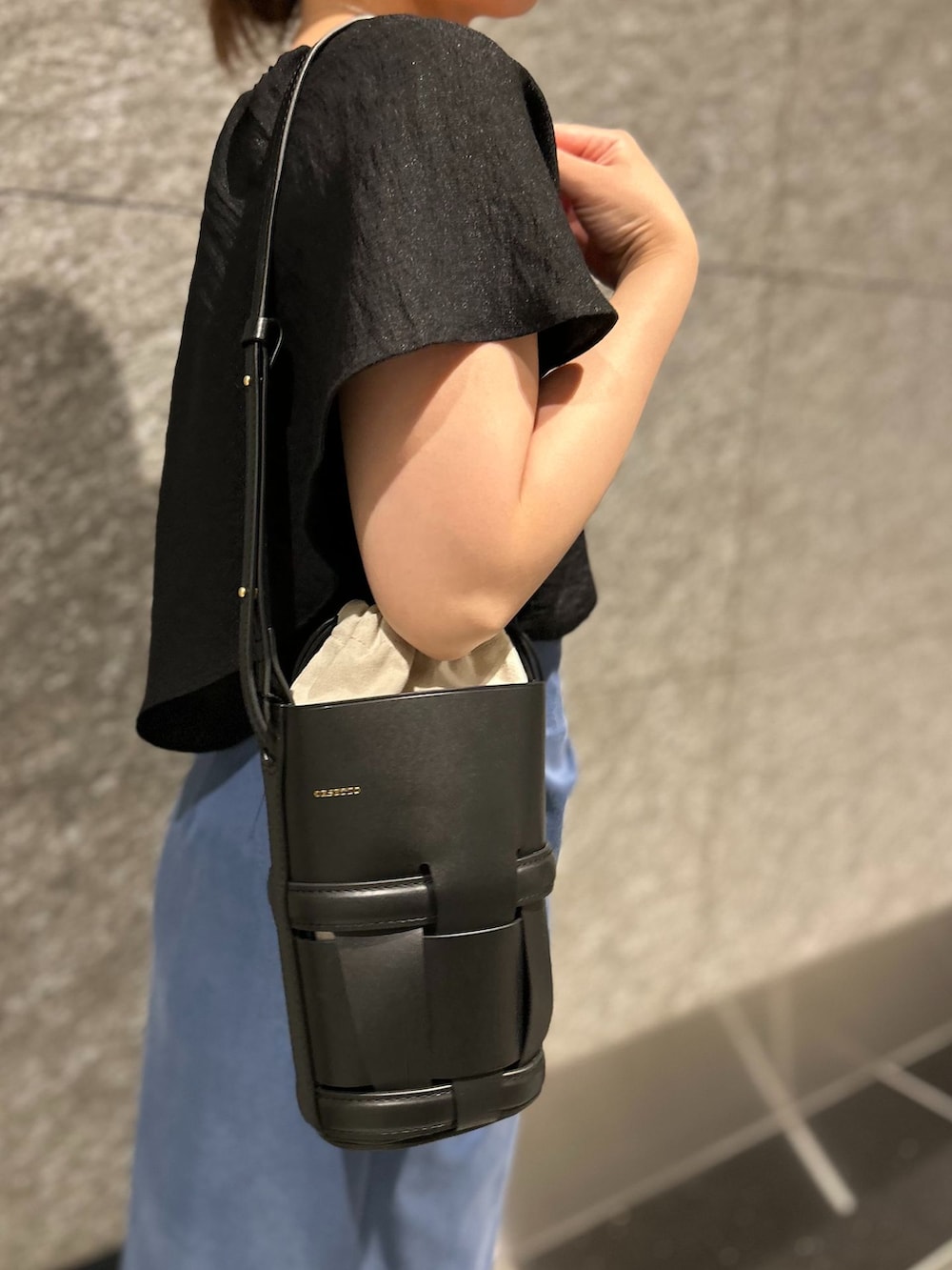 ブラック系のシャツ/ブラウス、ブルー系のスカート、ブラック系のショルダーバッグを着用したレディースの夏コーディネートの6枚目の写真