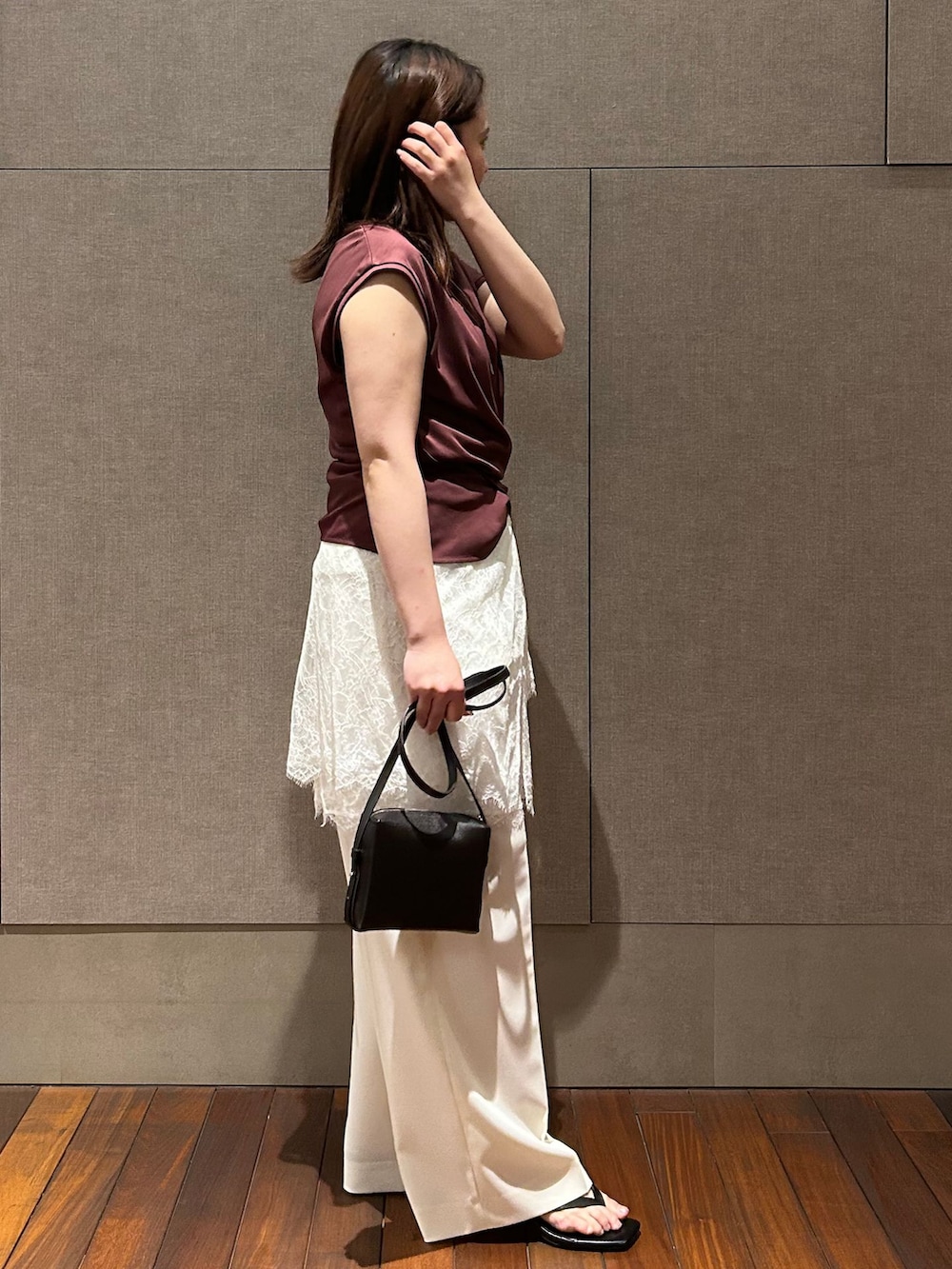 ホワイト系のスラックス、ホワイト系のシャツ/ブラウス、レッド系のTシャツ/カットソーを着用したレディースの春コーディネートの4枚目の写真