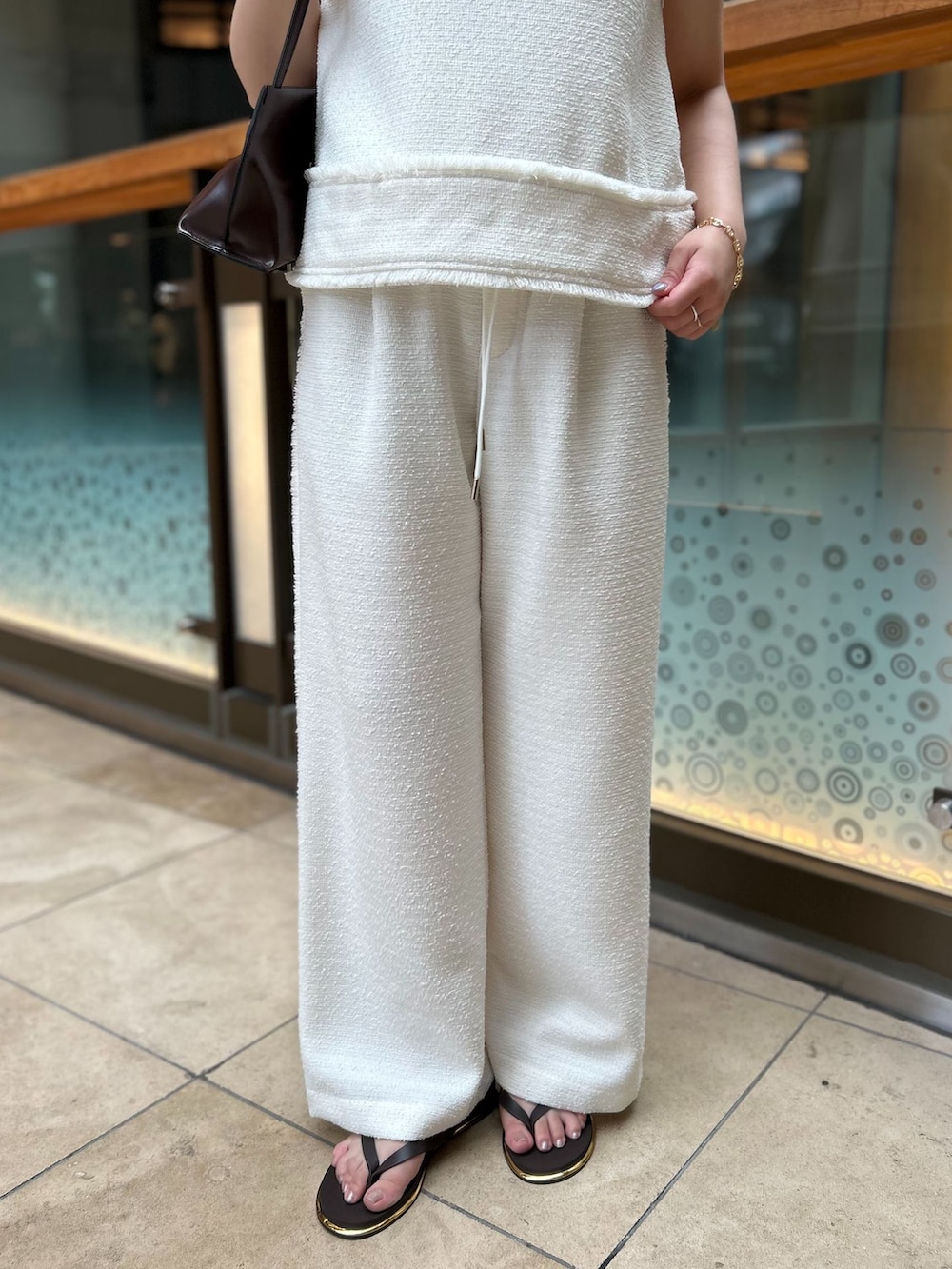 ホワイト系のその他パンツ、ホワイト系のシャツ/ブラウス、ブラウン系のショルダーバッグを着用したレディースの夏コーディネートの6枚目の写真