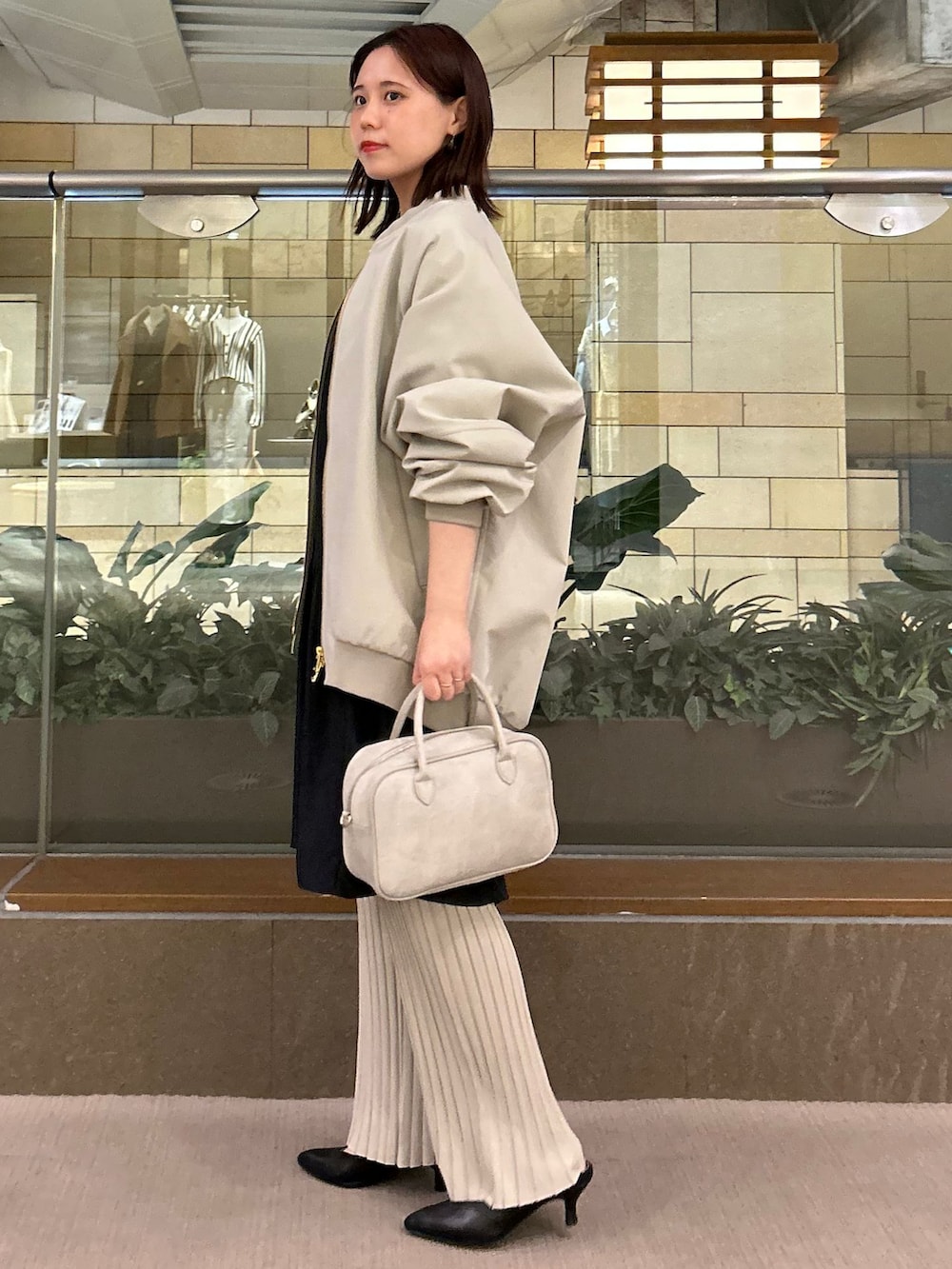 グリーン系のMA-1、ベージュ系のその他パンツ、ブラック系のワンピースを着用したレディースの冬コーディネートの3枚目の写真