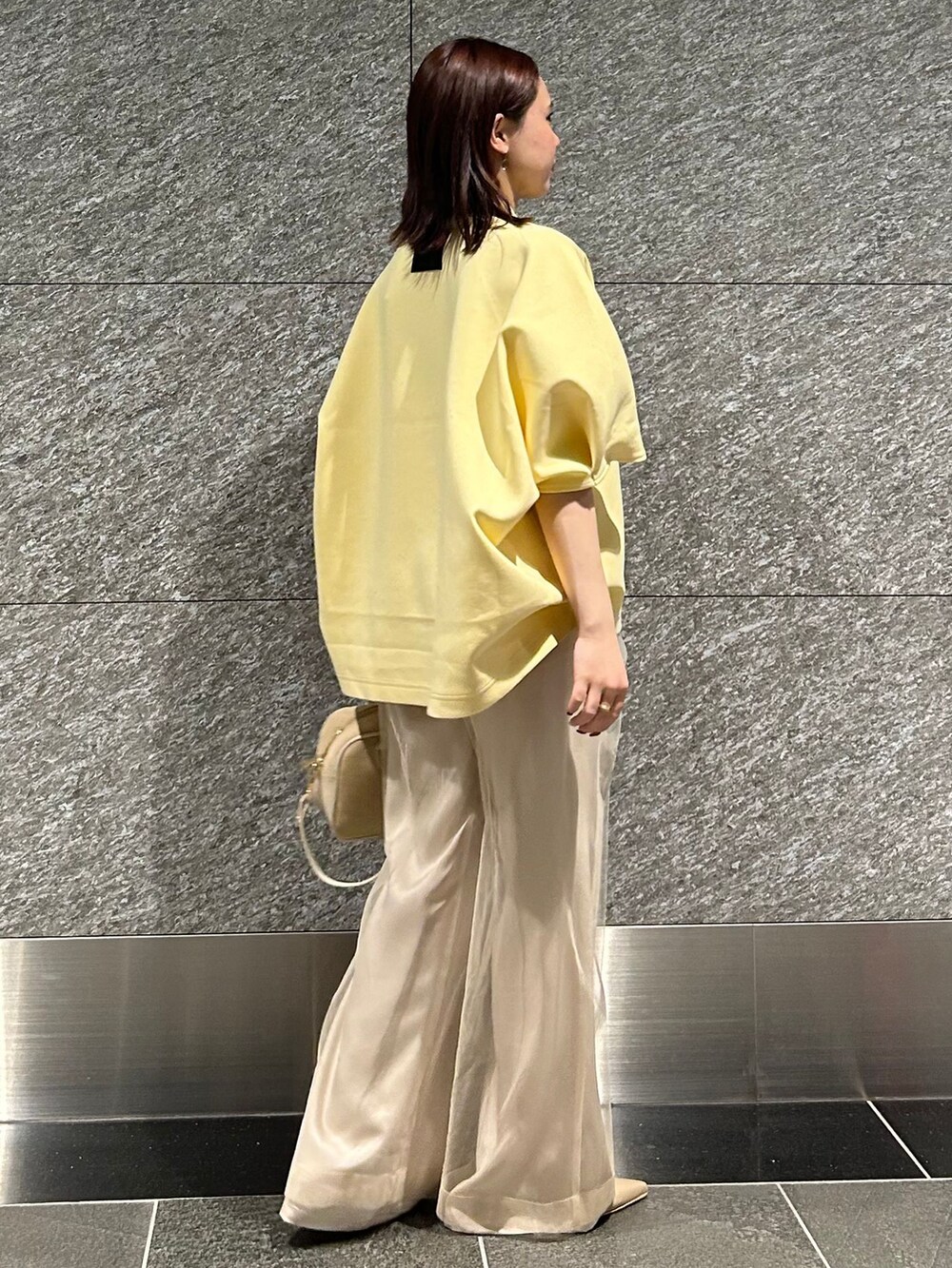 ベージュ系のスラックス、ベージュ系のスラックス、イエロー系のTシャツ/カットソーを着用したレディースの冬コーディネートの4枚目の写真
