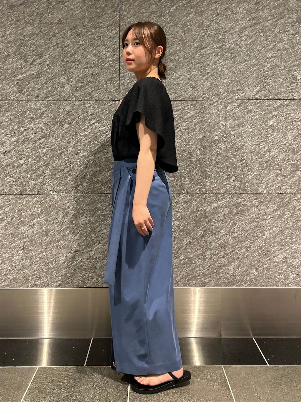 ブラック系のシャツ/ブラウス、ブルー系のスカート、ブラック系のショルダーバッグを着用したレディースの夏コーディネートの2枚目の写真