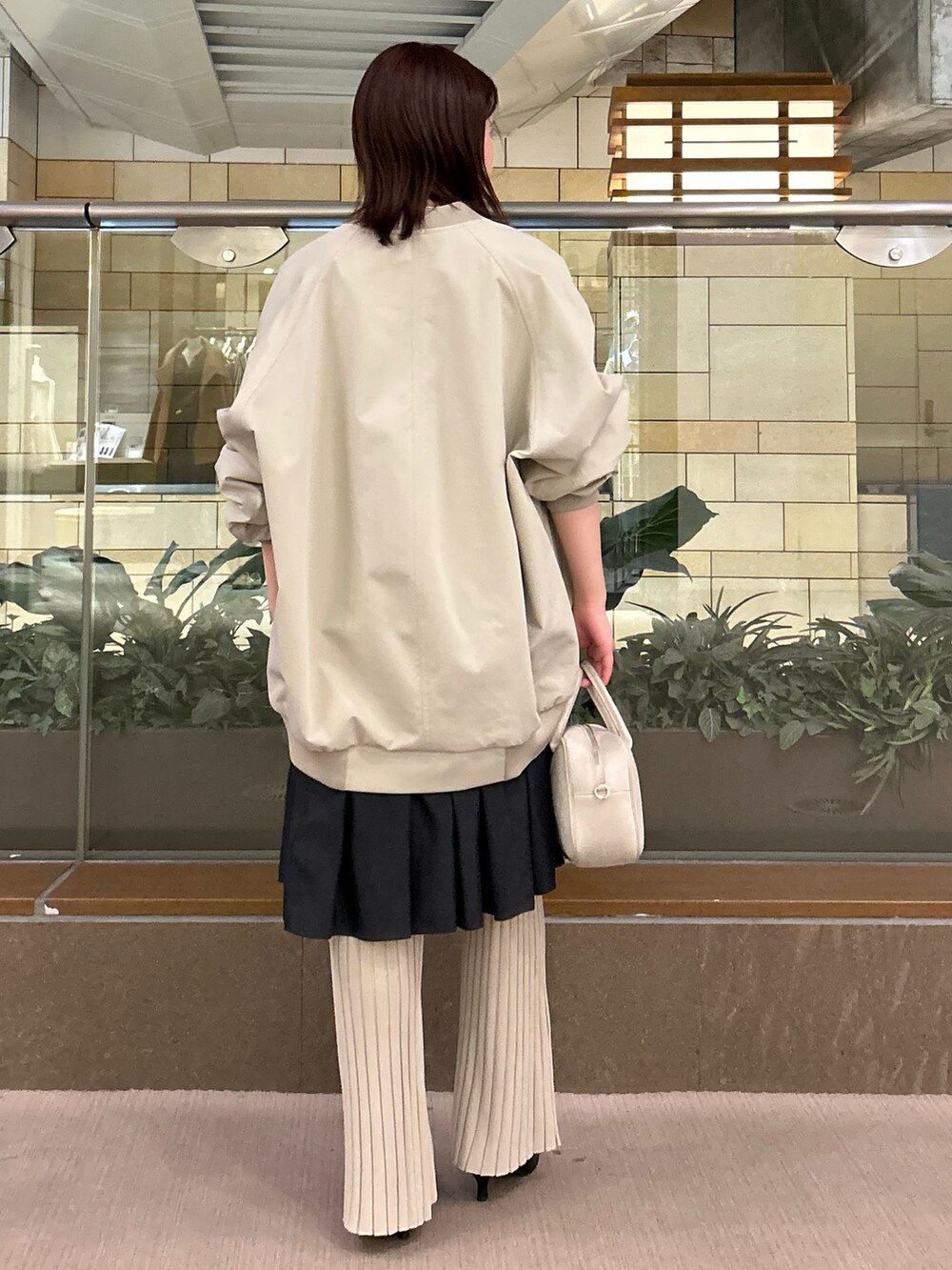 グリーン系のMA-1、ベージュ系のその他パンツ、ブラック系のワンピースを着用したレディースの冬コーディネートの2枚目の写真