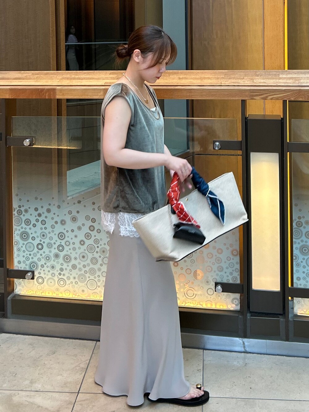 ホワイト系のキャミソール、ベージュ系のスカート、グリーン系のTシャツ/カットソーを着用したレディースの夏コーディネートの5枚目の写真