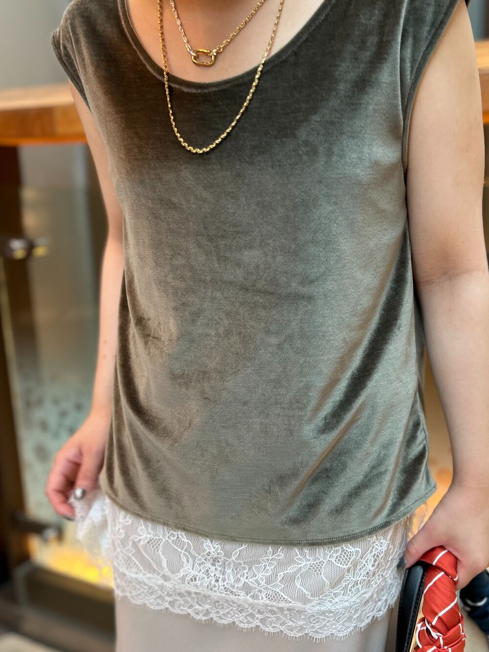ホワイト系のキャミソール、ベージュ系のスカート、グリーン系のTシャツ/カットソーを着用したレディースの夏コーディネートの7枚目の写真