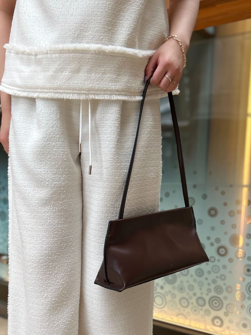 ホワイト系のその他パンツ、ホワイト系のシャツ/ブラウス、ブラウン系のショルダーバッグを着用したレディースの夏コーディネートの8枚目の写真