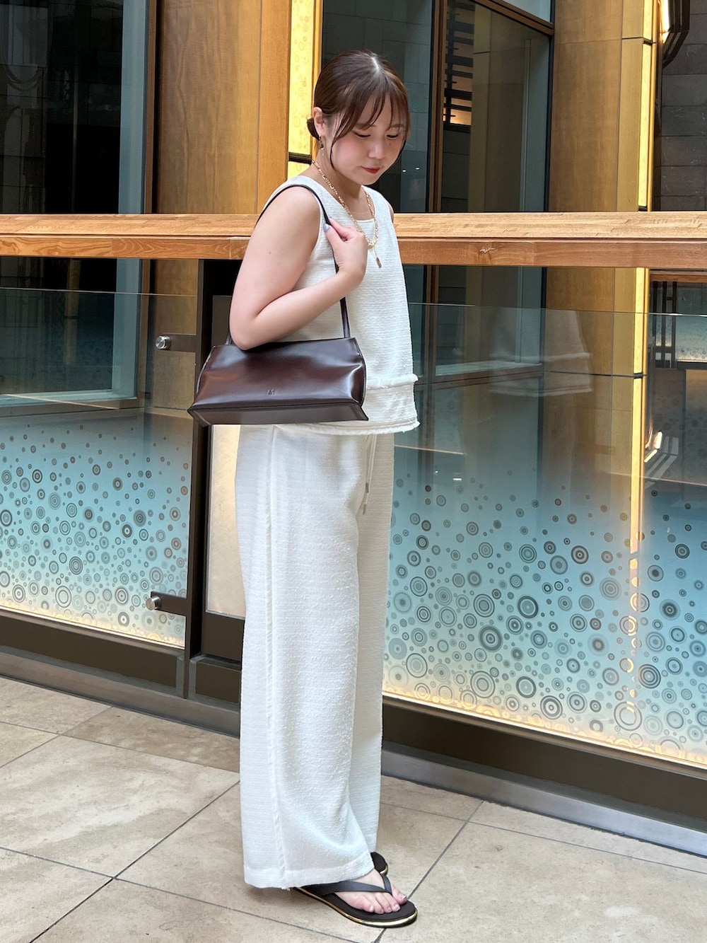ホワイト系のその他パンツ、ホワイト系のシャツ/ブラウス、ブラウン系のショルダーバッグを着用したレディースの夏コーディネートの4枚目の写真