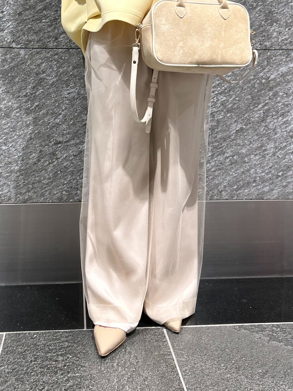 ベージュ系のスラックス、ベージュ系のスラックス、イエロー系のTシャツ/カットソーを着用したレディースの冬コーディネートの9枚目の写真