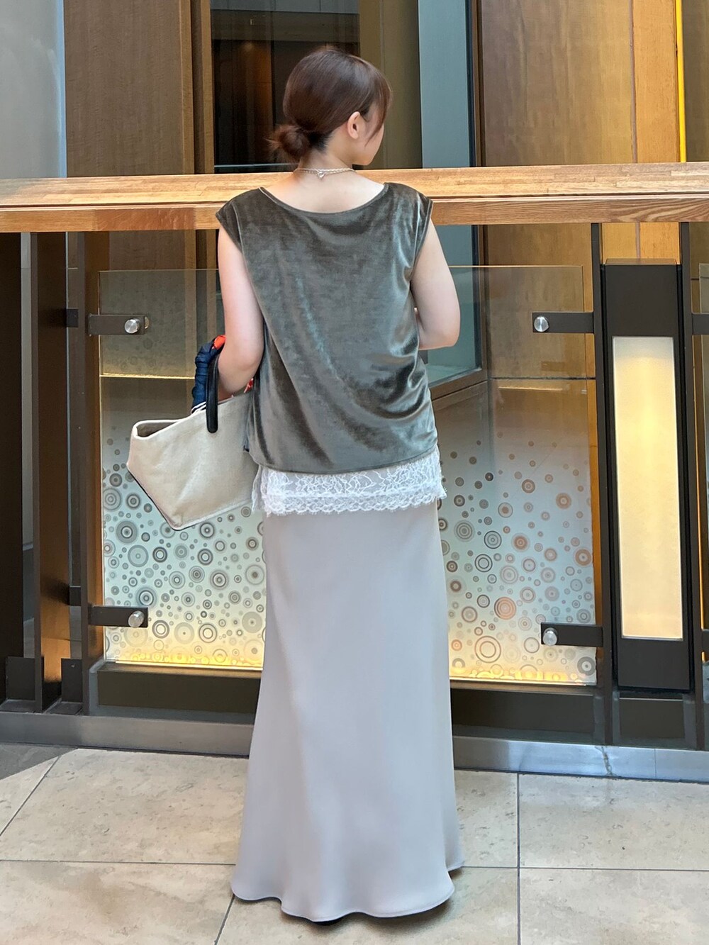 ホワイト系のキャミソール、ベージュ系のスカート、グリーン系のTシャツ/カットソーを着用したレディースの夏コーディネートの4枚目の写真