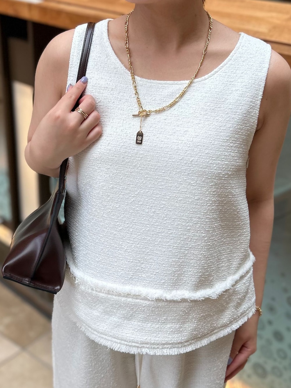 ホワイト系のその他パンツ、ホワイト系のシャツ/ブラウス、ブラウン系のショルダーバッグを着用したレディースの夏コーディネートの5枚目の写真