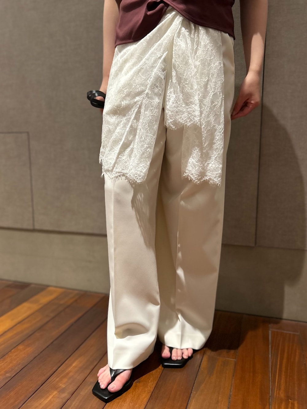 ホワイト系のスラックス、ホワイト系のシャツ/ブラウス、レッド系のTシャツ/カットソーを着用したレディースの春コーディネートの6枚目の写真