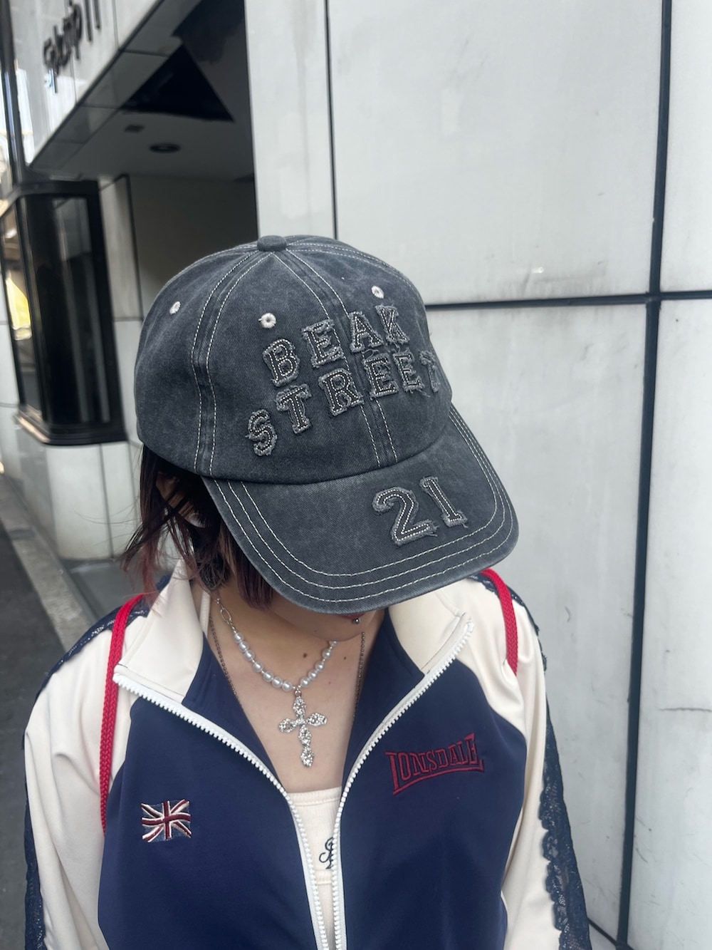 ブラック系のスカート、ブルー系のジャージ、ホワイト系のキャミソールを着用したレディースの春コーディネートの9枚目の写真