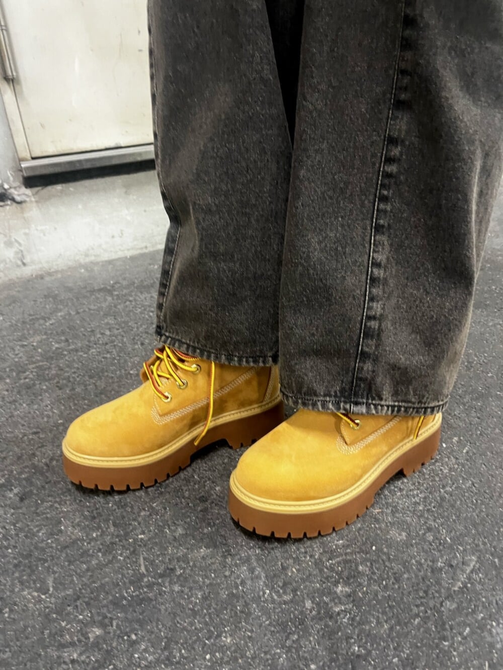 ブラック系のパーカー、ブラウン系のカーディガン/ボレロ、ブラック系のデニムパンツを着用したレディースの春コーディネートの10枚目の写真