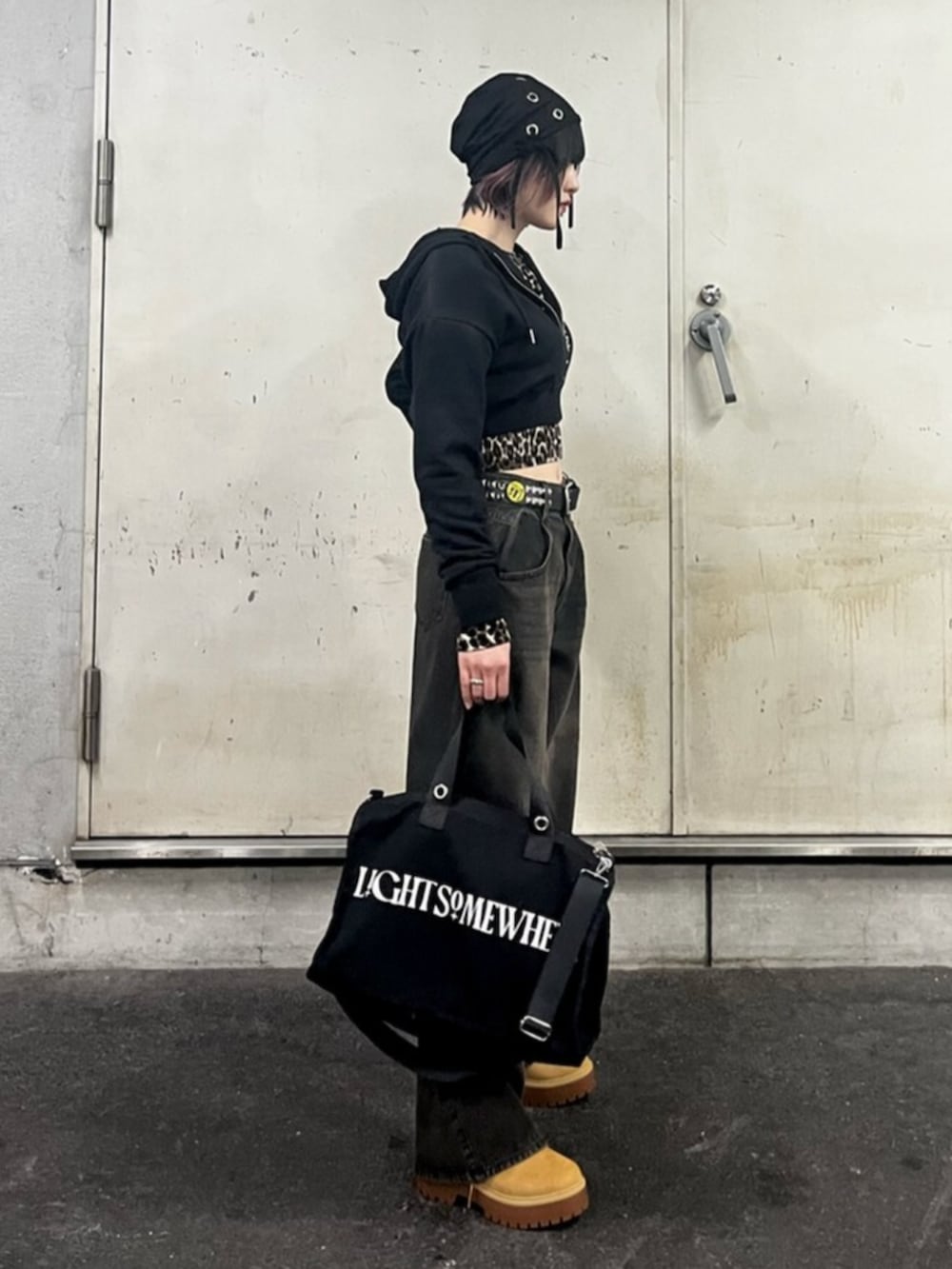 ブラック系のパーカー、ブラウン系のカーディガン/ボレロ、ブラック系のデニムパンツを着用したレディースの春コーディネートの4枚目の写真