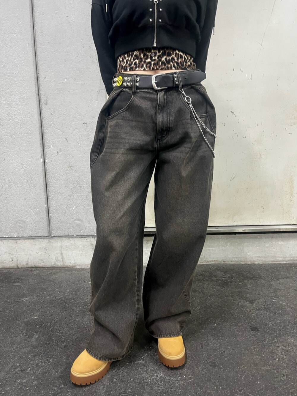 ブラック系のパーカー、ブラウン系のカーディガン/ボレロ、ブラック系のデニムパンツを着用したレディースの春コーディネートの8枚目の写真