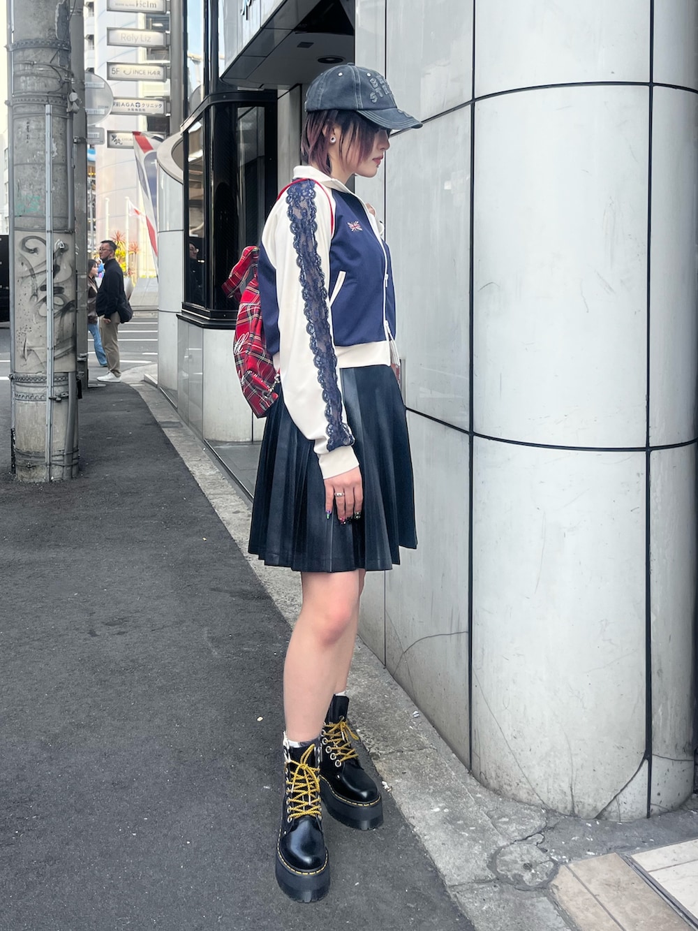 ブラック系のスカート、ブルー系のジャージ、ホワイト系のキャミソールを着用したレディースの春コーディネートの4枚目の写真