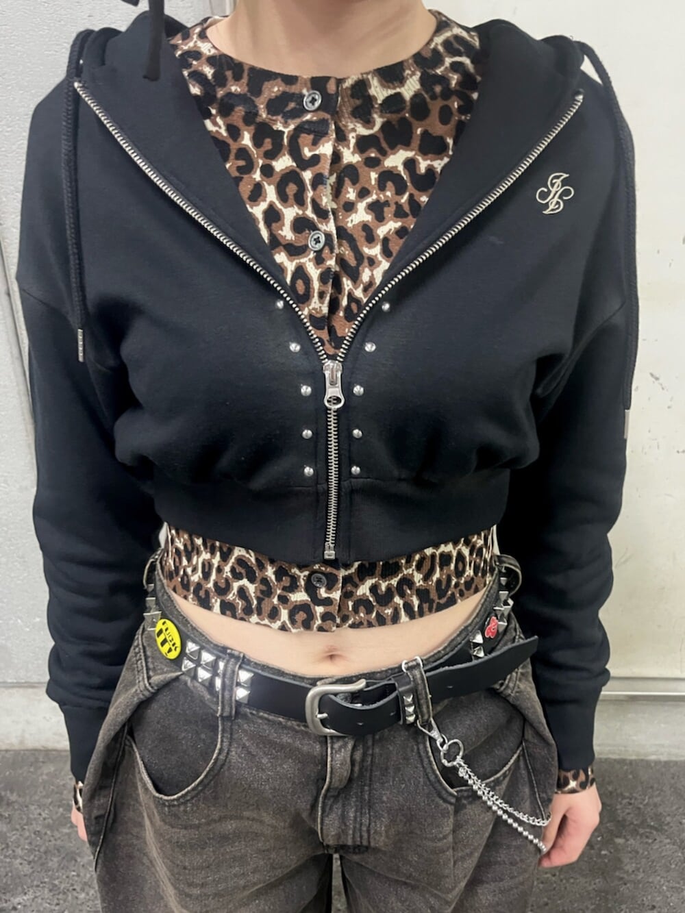 ブラック系のパーカー、ブラウン系のカーディガン/ボレロ、ブラック系のデニムパンツを着用したレディースの春コーディネートの7枚目の写真