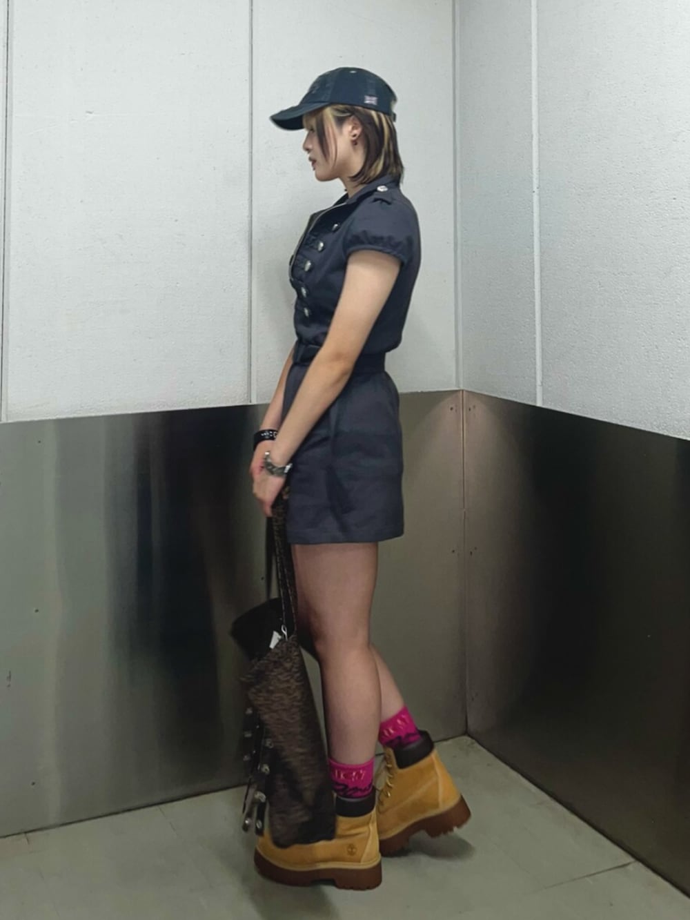 ベージュ系のブーツ、ブラウン系のタンクトップ、ブラック系のワンピースを着用したレディースの夏コーディネートの2枚目の写真