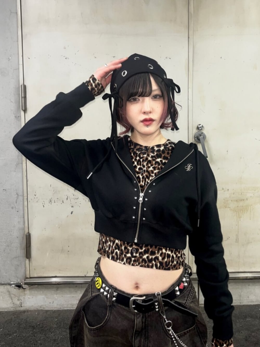 ブラック系のパーカー、ブラウン系のカーディガン/ボレロ、ブラック系のデニムパンツを着用したレディースの春コーディネートの6枚目の写真