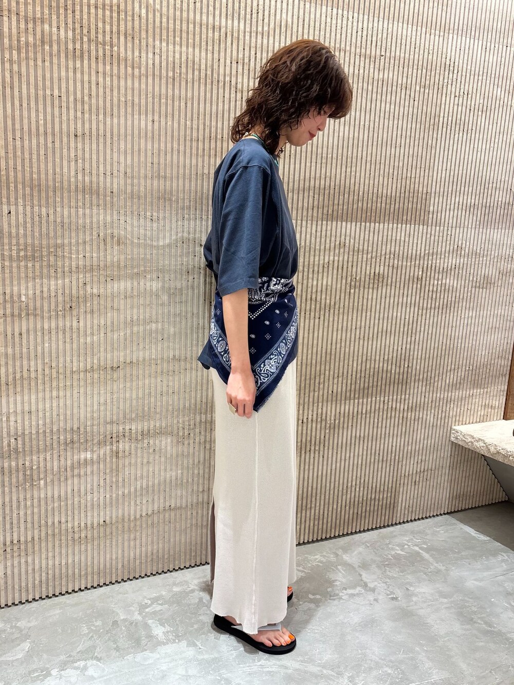 ホワイト系のスカート、ブルー系のTシャツ/カットソー、ブラック系のサンダルを着用したレディースの夏コーディネートの3枚目の写真