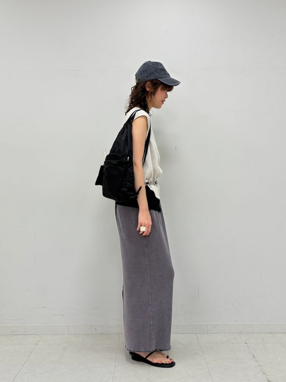 グレー系のスカート、ブラック系のタンクトップ、ホワイト系のTシャツ/カットソーを着用したレディースの夏コーディネートの4枚目の写真