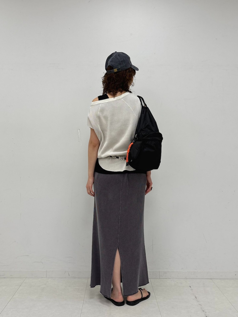 グレー系のスカート、ブラック系のタンクトップ、ホワイト系のTシャツ/カットソーを着用したレディースの夏コーディネートの5枚目の写真