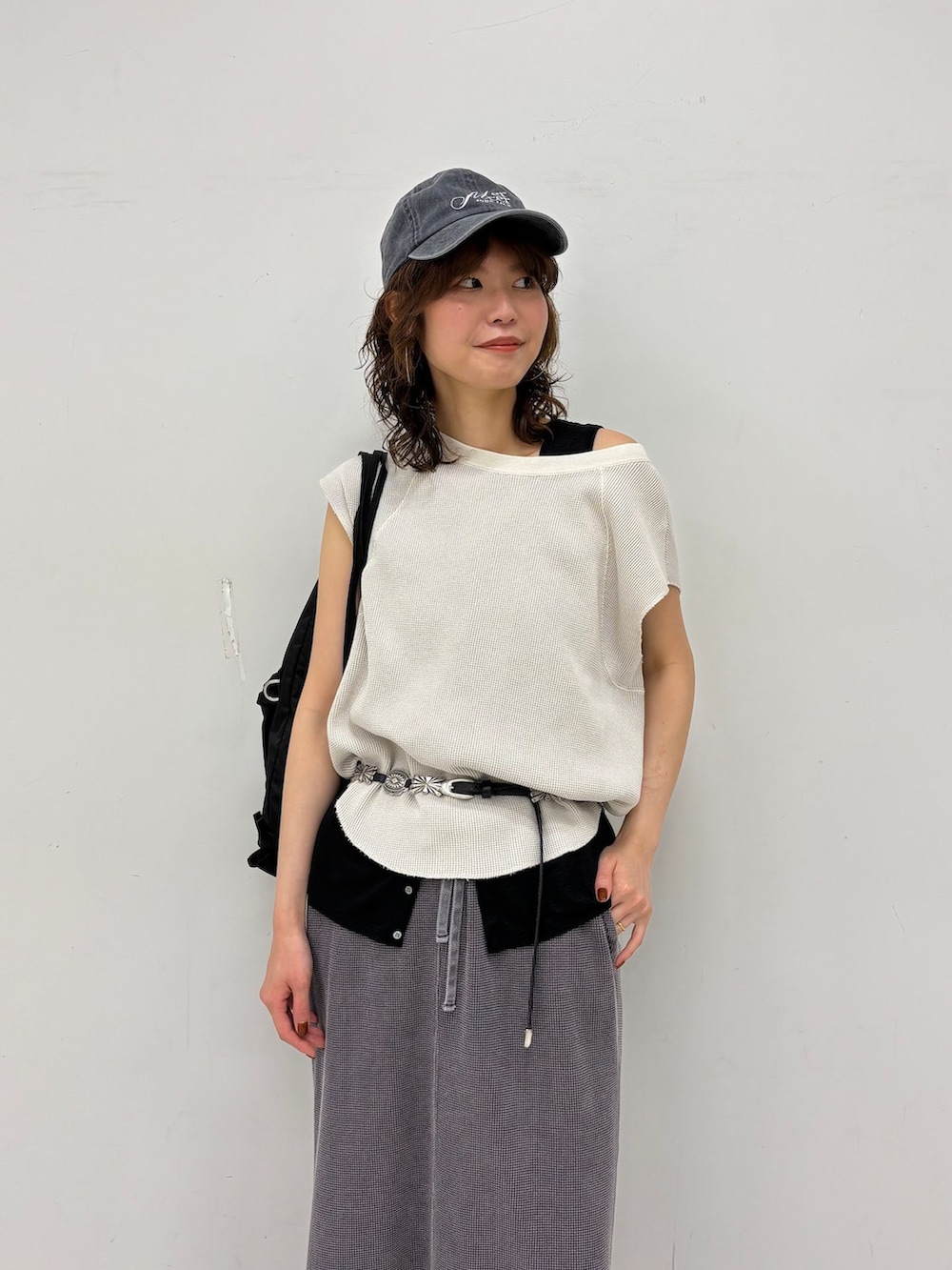 グレー系のスカート、ブラック系のタンクトップ、ホワイト系のTシャツ/カットソーを着用したレディースの夏コーディネートの7枚目の写真