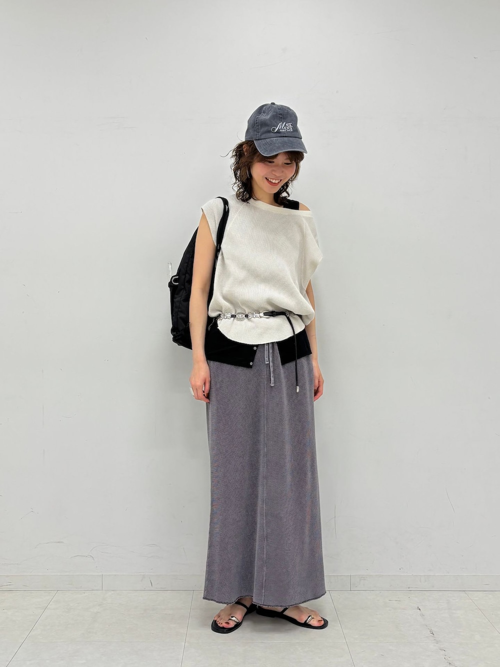 グレー系のスカート、ブラック系のタンクトップ、ホワイト系のTシャツ/カットソーを着用したレディースの夏コーディネートの2枚目の写真