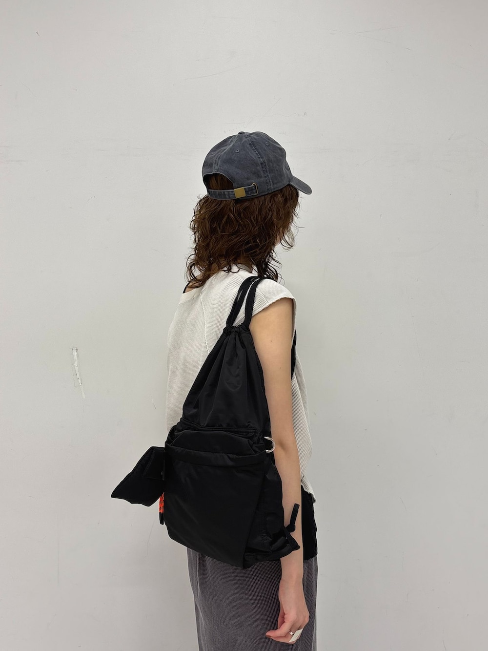 グレー系のスカート、ブラック系のタンクトップ、ホワイト系のTシャツ/カットソーを着用したレディースの夏コーディネートの8枚目の写真