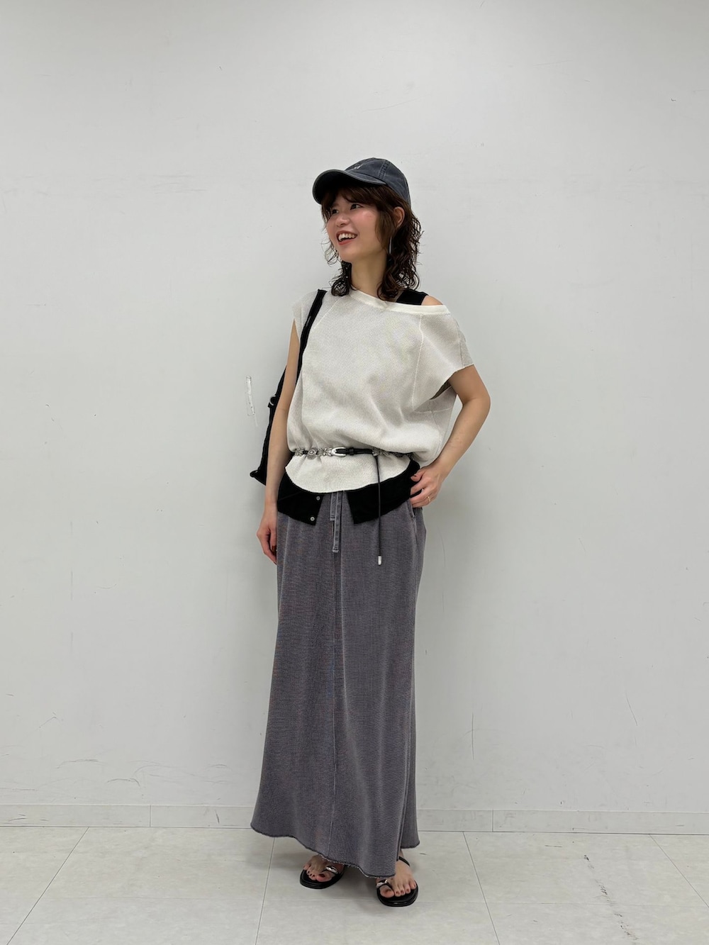 グレー系のスカート、ブラック系のタンクトップ、ホワイト系のTシャツ/カットソーを着用したレディースの夏コーディネートの3枚目の写真