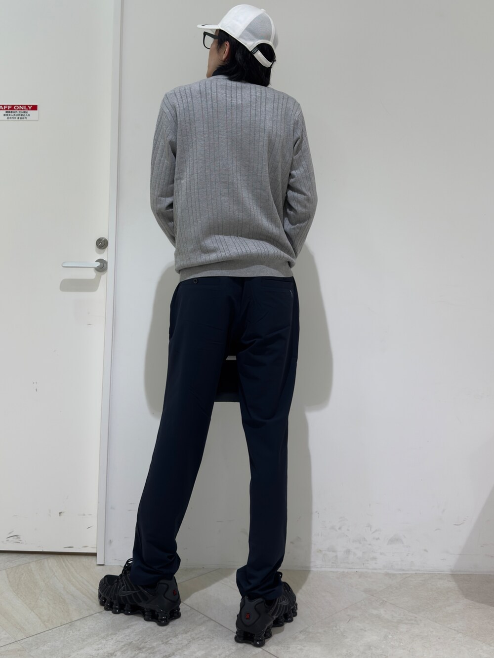 グレー系のニット/セーター、ブルー系のポロシャツ、ブルー系のトートバッグを着用したメンズの秋コーディネートの3枚目の写真