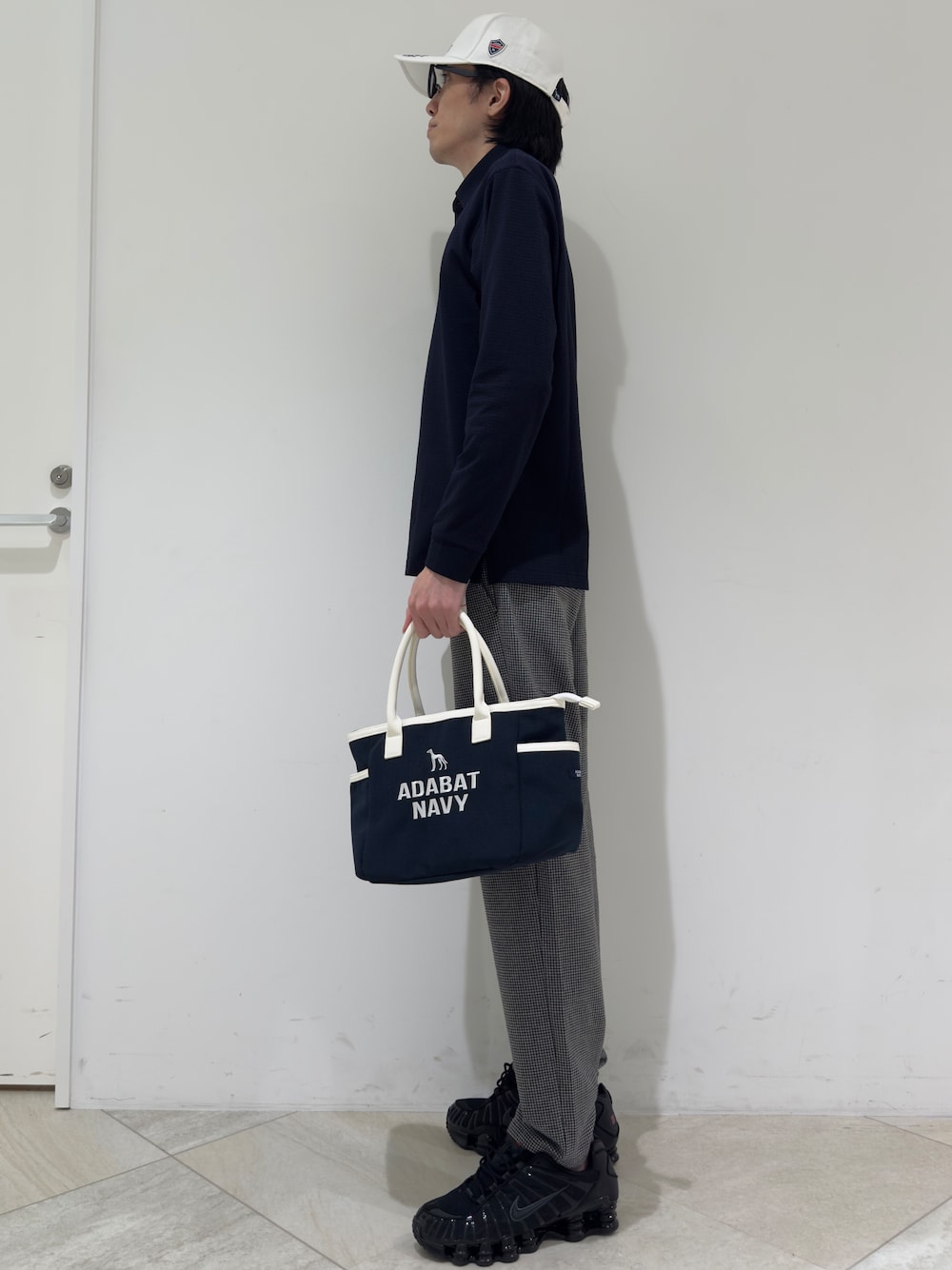 ブルー系のポロシャツ、グレー系のその他パンツ、ブルー系のトートバッグを着用したメンズの秋コーディネートの2枚目の写真