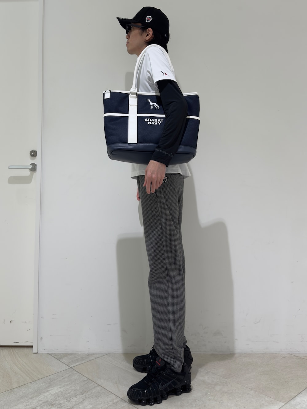ホワイト系のポロシャツ、ブラック系のTシャツ/カットソー、グレー系のその他パンツを着用したメンズの秋コーディネートの2枚目の写真