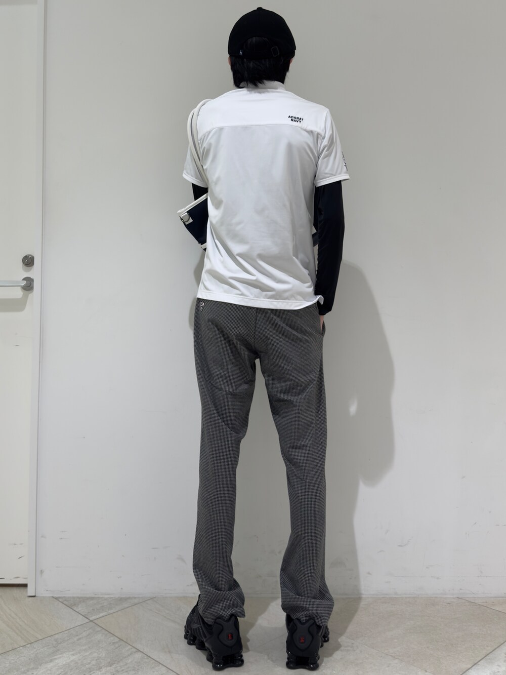 ホワイト系のポロシャツ、ブラック系のTシャツ/カットソー、グレー系のその他パンツを着用したメンズの秋コーディネートの3枚目の写真