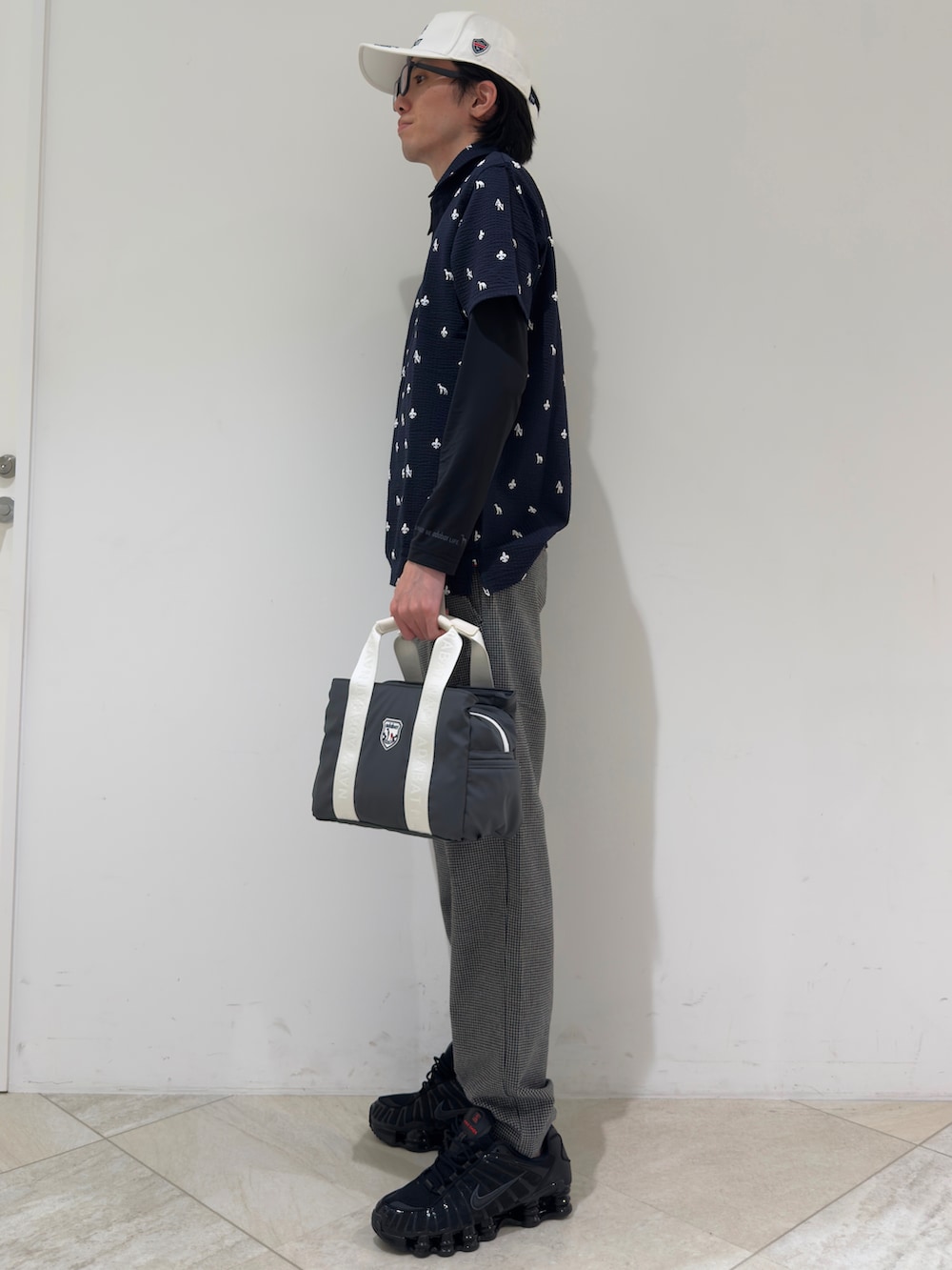 ブルー系のポロシャツ、ブラック系のTシャツ/カットソー、グレー系のその他パンツを着用したメンズの秋コーディネートの2枚目の写真