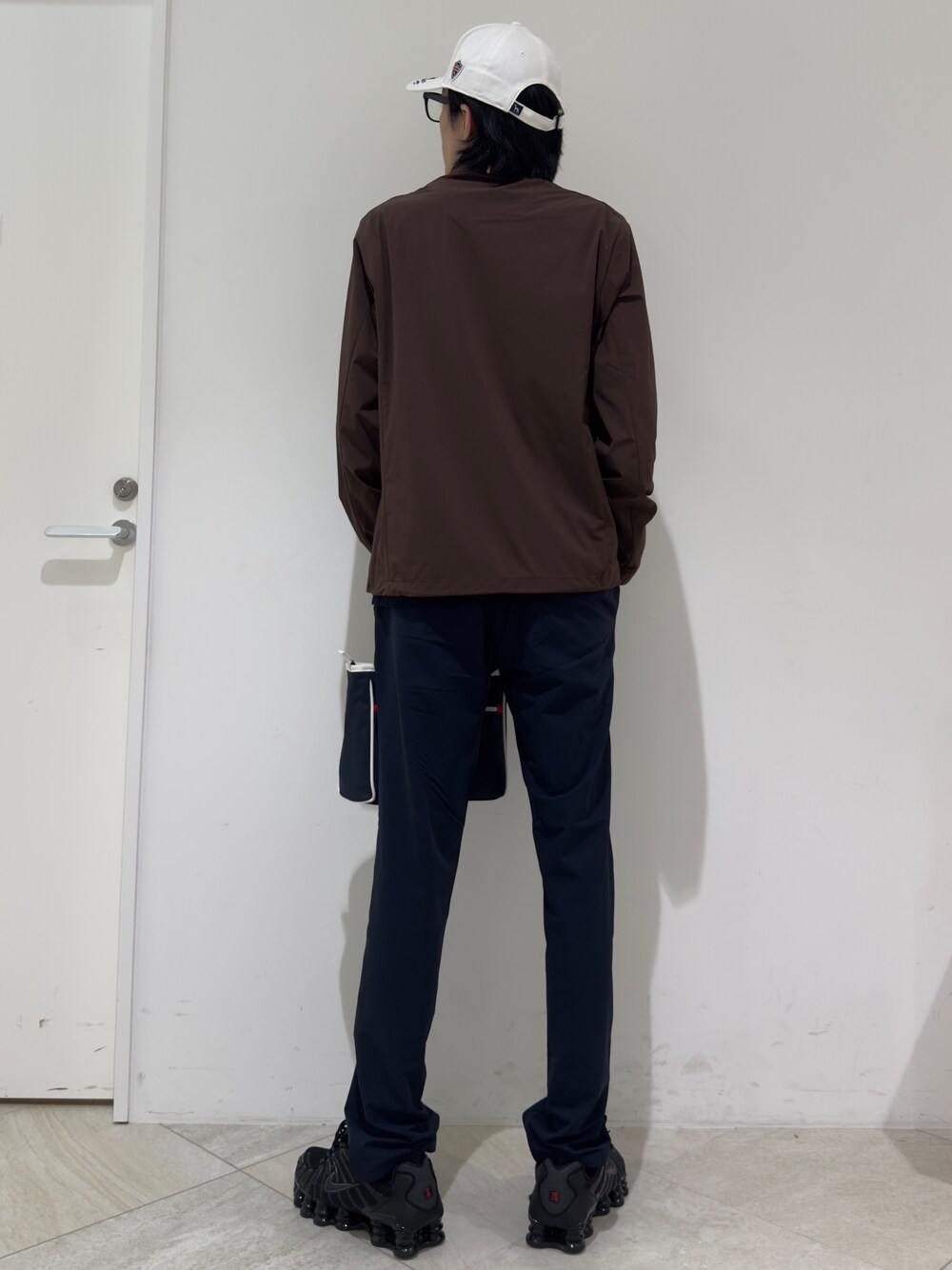 ブラウン系のブルゾン、ブルー系のトートバッグ、ホワイト系のキャップを着用したメンズの秋コーディネートの3枚目の写真