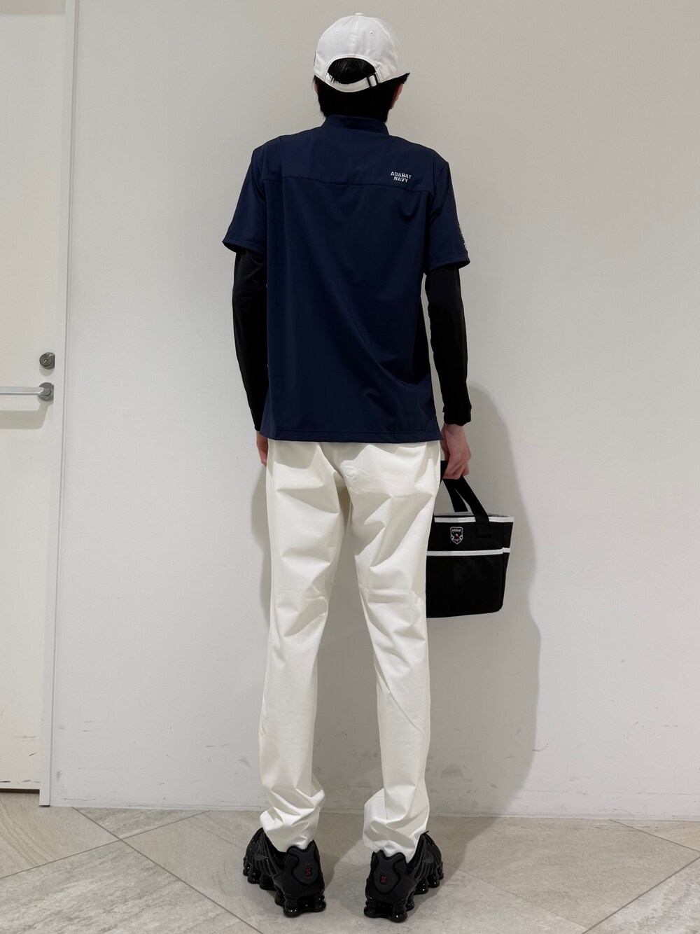 ブルー系のポロシャツ、ブラック系のTシャツ/カットソー、ホワイト系のその他パンツを着用したメンズの夏コーディネートの3枚目の写真