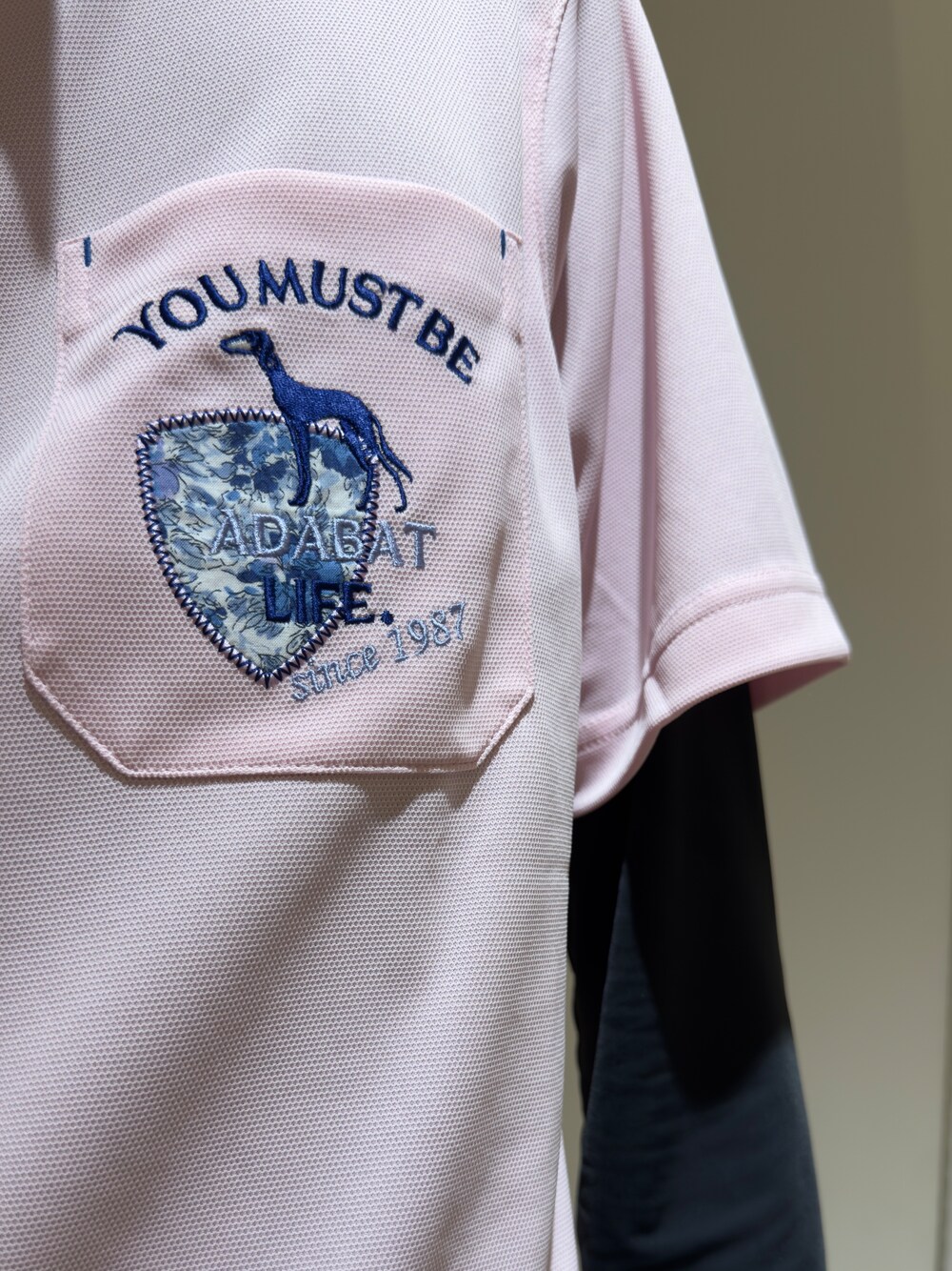 ピンク系のポロシャツ、ブラック系のTシャツ/カットソー、ホワイト系のその他パンツを着用したメンズの夏コーディネートの4枚目の写真