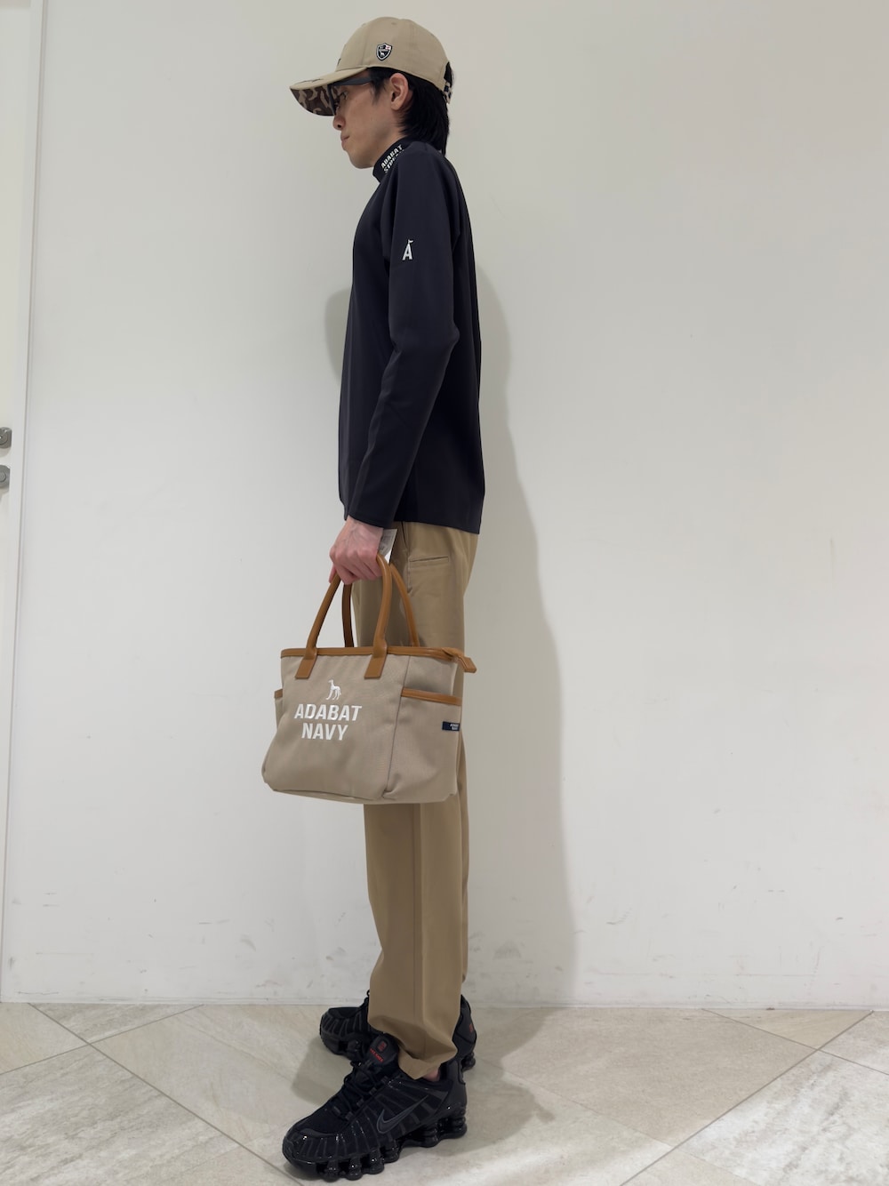 ブラック系のTシャツ/カットソー、ベージュ系のその他パンツ、ベージュ系のトートバッグを着用したメンズの夏コーディネートの2枚目の写真