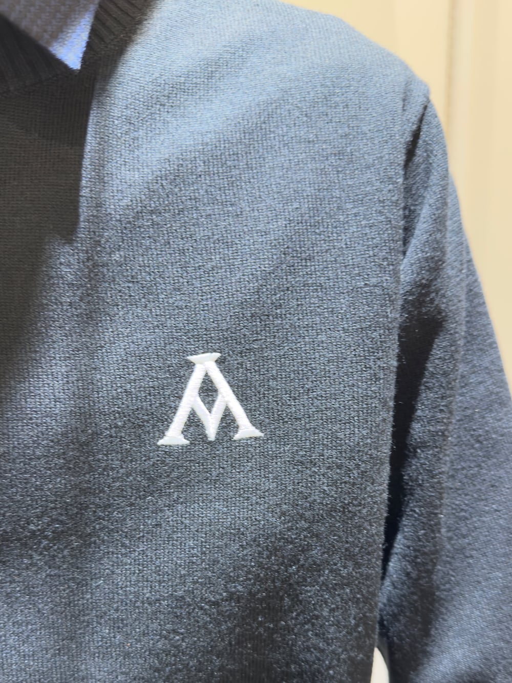 ブラック系のニット/セーター、ブルー系のポロシャツ、グレー系のその他パンツを着用したメンズの秋コーディネートの5枚目の写真