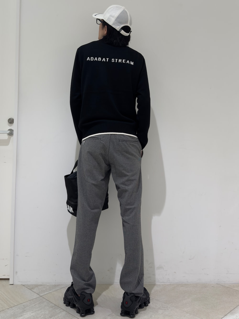 ブラック系のニット/セーター、ブルー系のポロシャツ、グレー系のその他パンツを着用したメンズの秋コーディネートの3枚目の写真