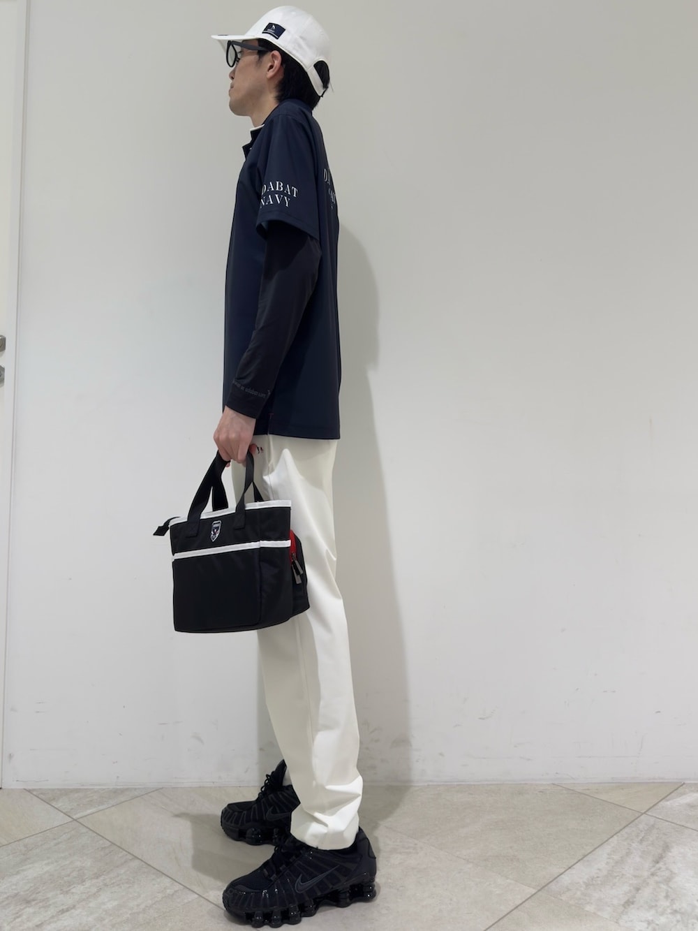 ブルー系のポロシャツ、ブラック系のTシャツ/カットソー、ホワイト系のその他パンツを着用したメンズの夏コーディネートの2枚目の写真