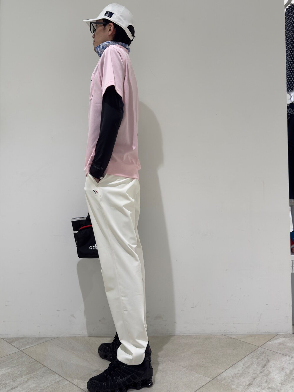 ピンク系のポロシャツ、ブラック系のTシャツ/カットソー、ホワイト系のその他パンツを着用したメンズの夏コーディネートの2枚目の写真