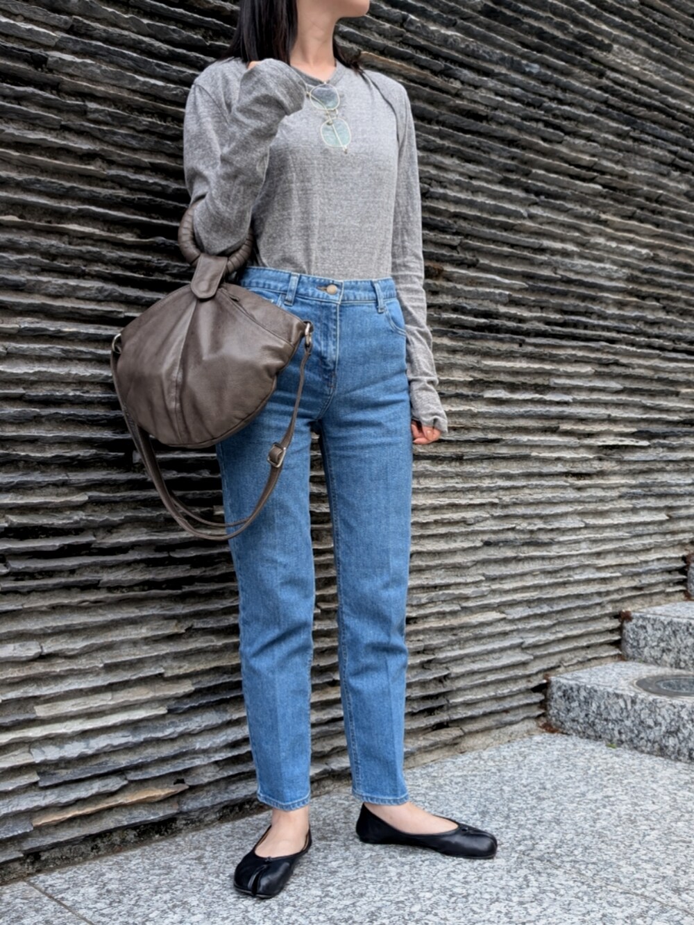 グレー系のTシャツ/カットソー、ブルー系のデニムパンツ、ブラック系のバレエシューズを着用したレディースの春コーディネートの2枚目の写真