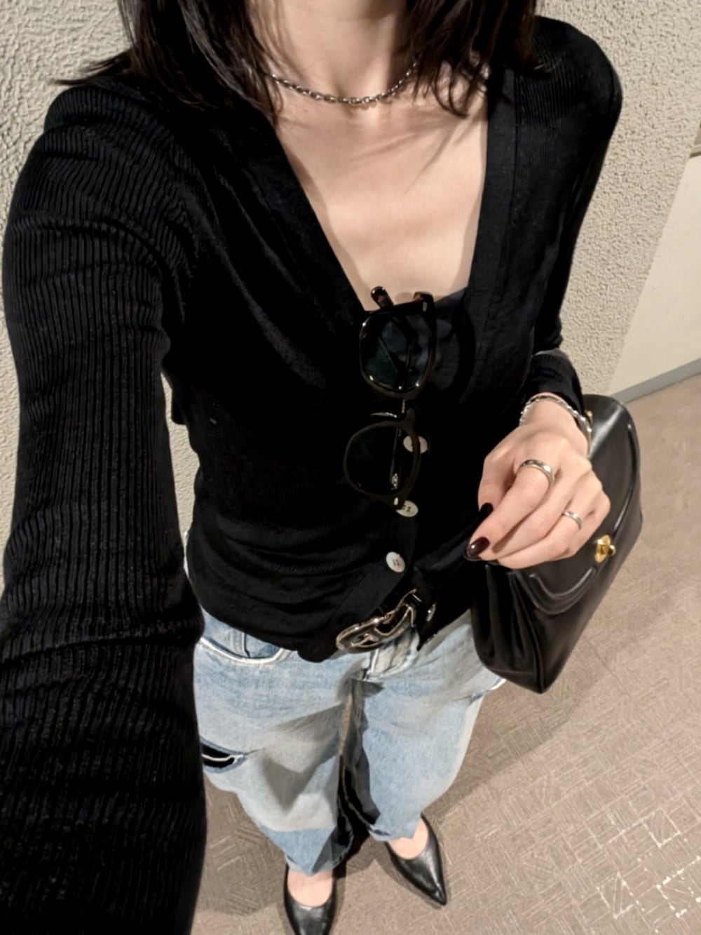 ブルー系のデニムパンツ、ブラック系のパンプス、ブラック系のハンドバッグを着用したレディースの春コーディネートの2枚目の写真
