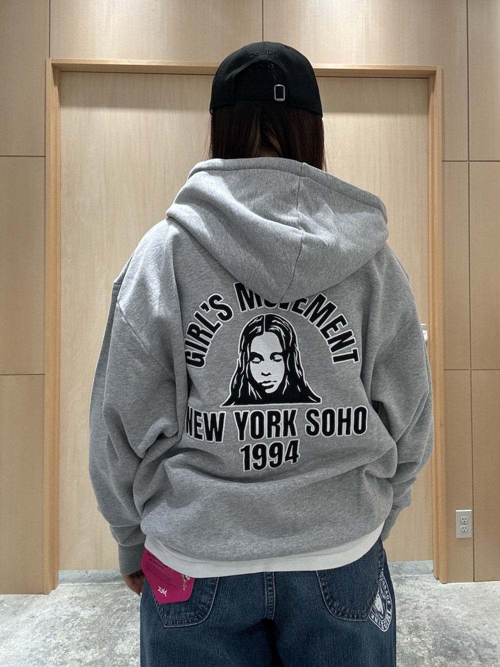 グレー系のパーカー、ホワイト系のTシャツ/カットソー、ブルー系のデニムパンツを着用したレディースの秋コーディネートの4枚目の写真
