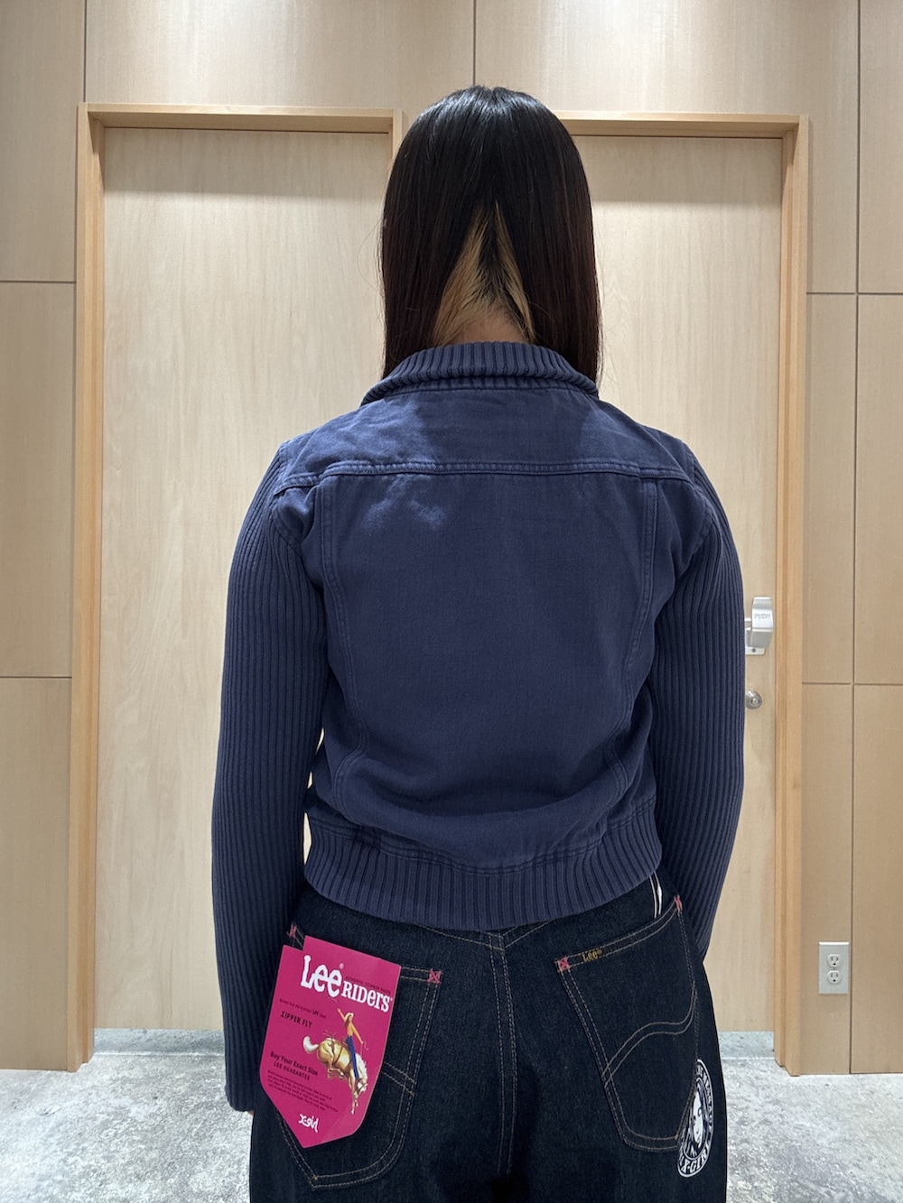 ブルー系のブルゾン、ブルー系のデニムパンツ、ホワイト系のハンドバッグを着用したレディースの夏コーディネートの4枚目の写真