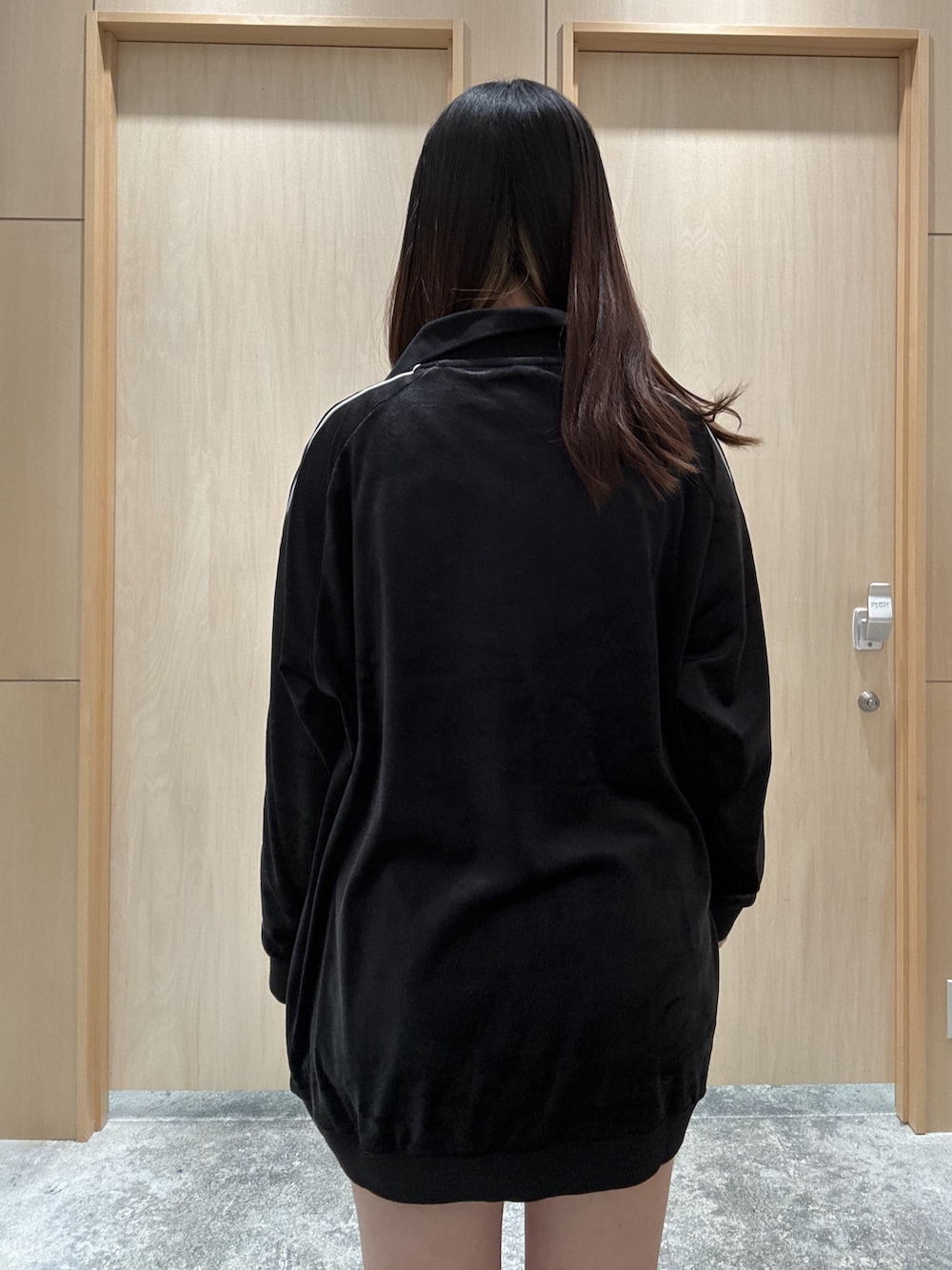 ブラック系のワンピース、ブラウン系のバックパック/リュック、ブルー系のデニムパンツを着用したレディースの秋コーディネートの4枚目の写真